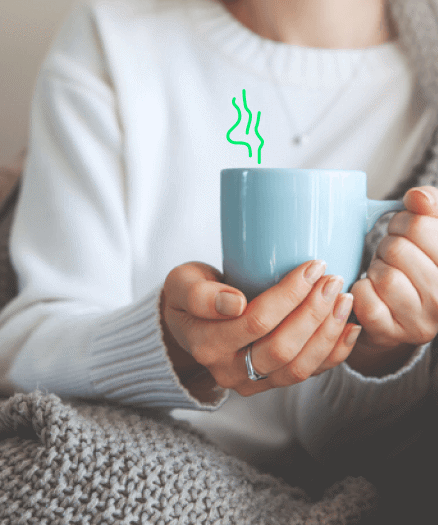 Lady holding hot drink at home.